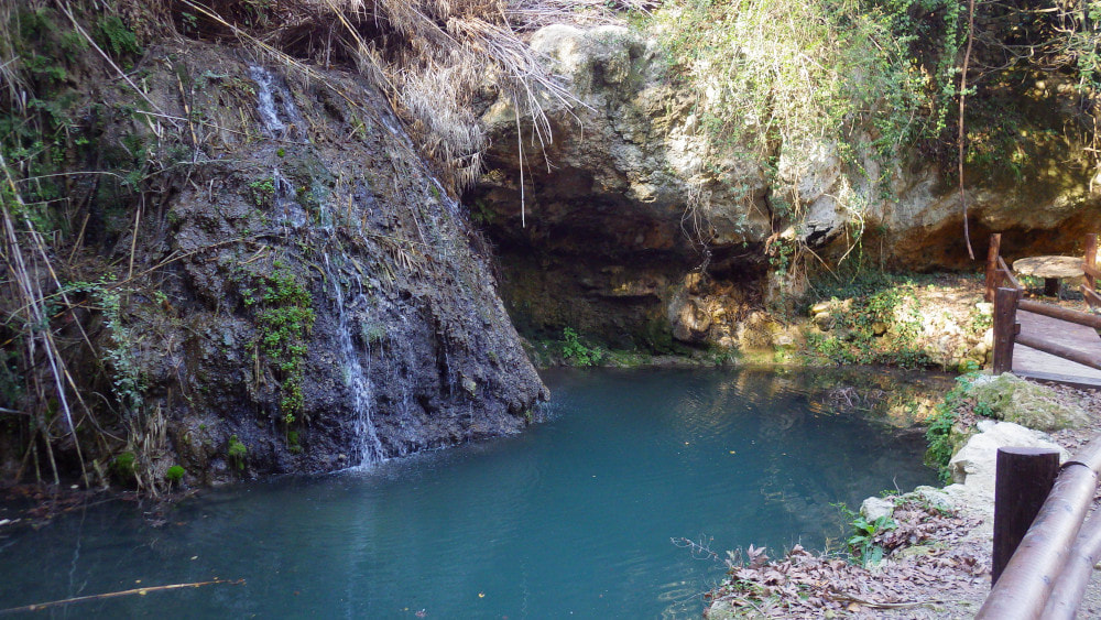 A blue natural pool at a waterfall