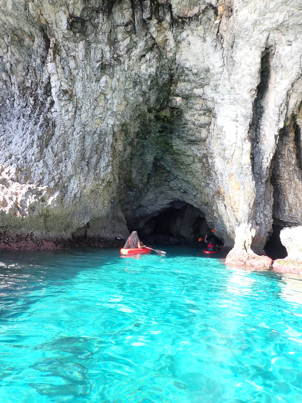 Two kayakers entering a sea cave