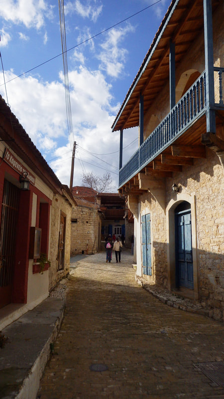 Two walkers on an alley in a stone-built village